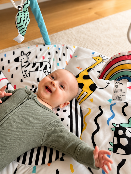 A happy, thriving baby smiling on a play mat